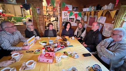 Group of men and women sitting around a table talking